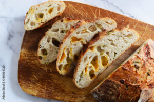 Sliced jalapeños cheddar sourdough bread on a wooden cutting board