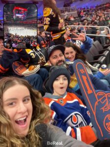a family sitting at a hockey game cheering with a foam finger