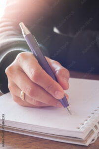 Woman hand with pen writing on notebook