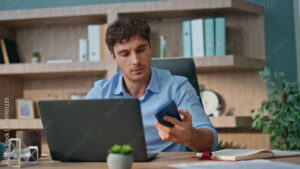 Man distracted by cellphone while working