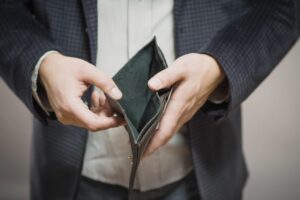 Man opening up empty wallet. 