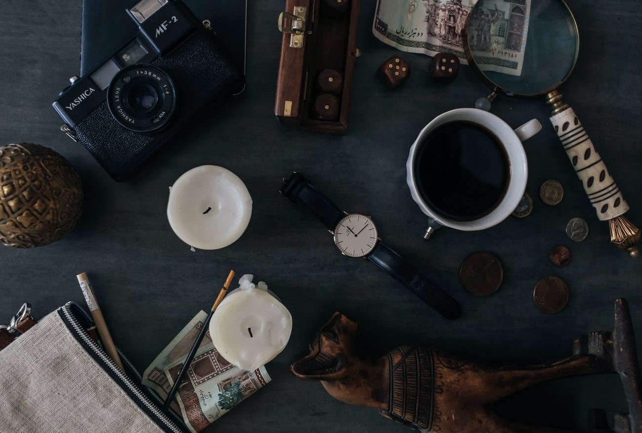 old photo camera near candles and cup of coffee