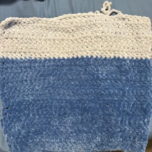 grey and blue crochet blanket laying flat.