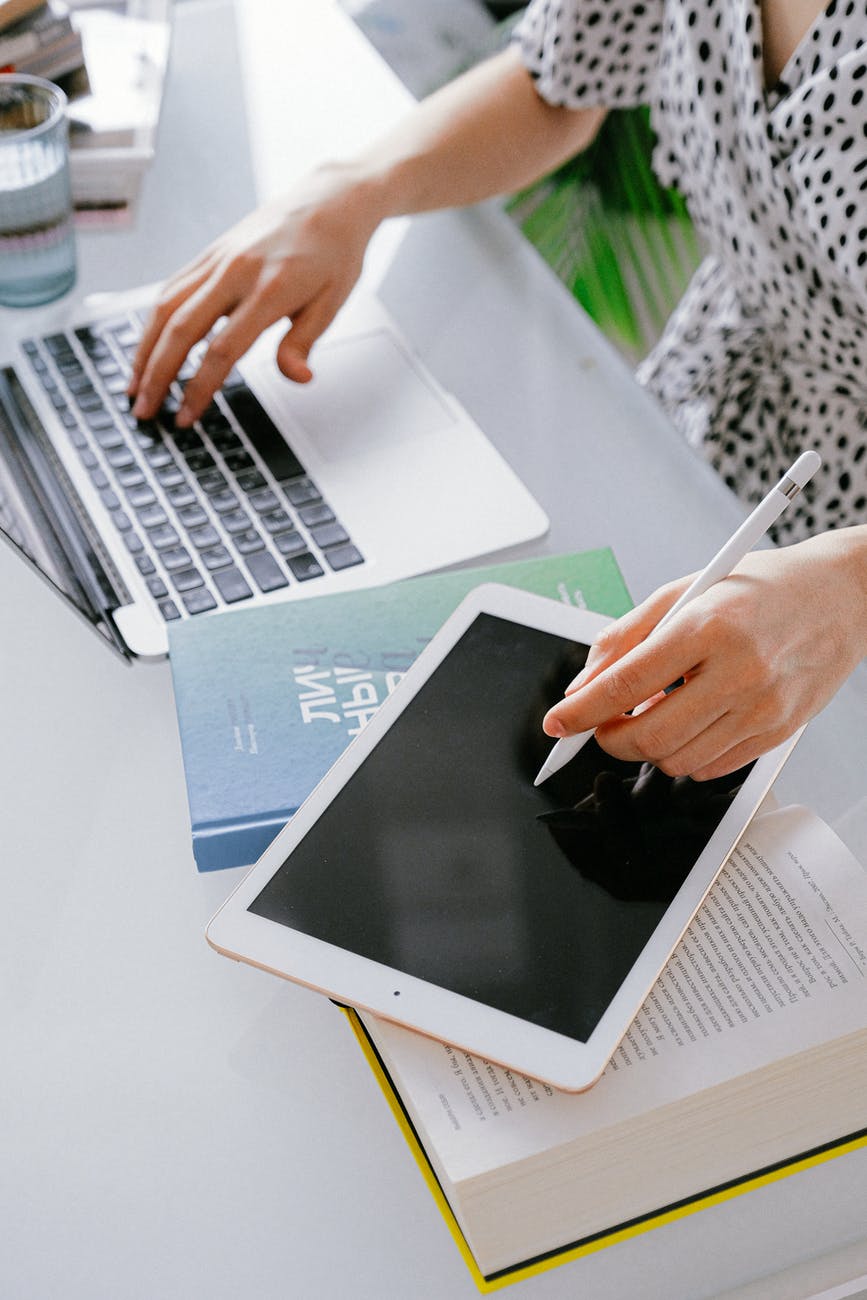 person using macbook and ipad