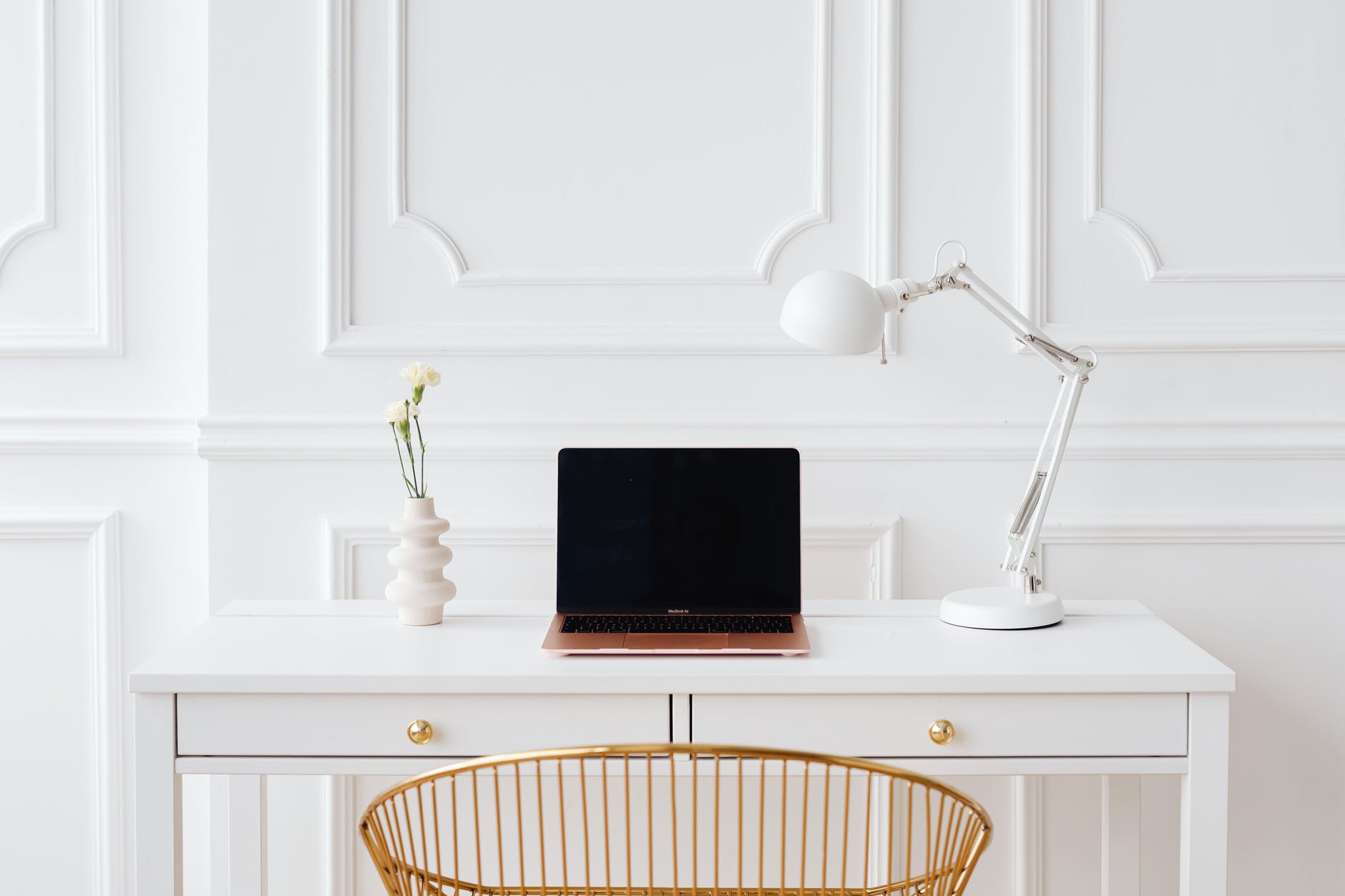 laptop on a wooden white desk