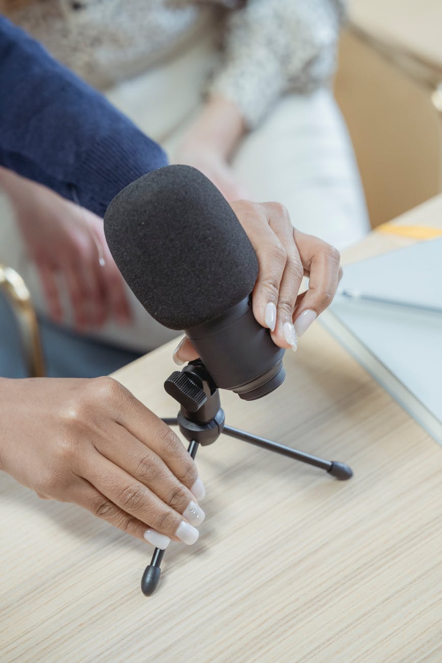 crop woman setting up microphone before podcasting